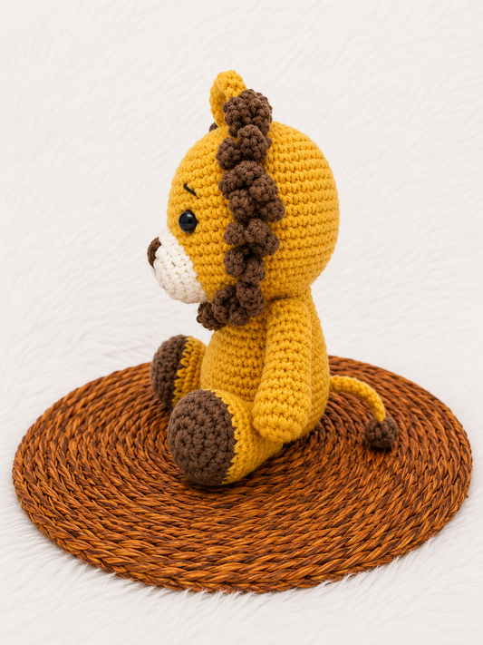 Leo the Crochet Lion handmade amigurumi plush toy with a golden yellow body, textured brown mane, and adorable handcrafted detailing, displayed on a woven mat.
