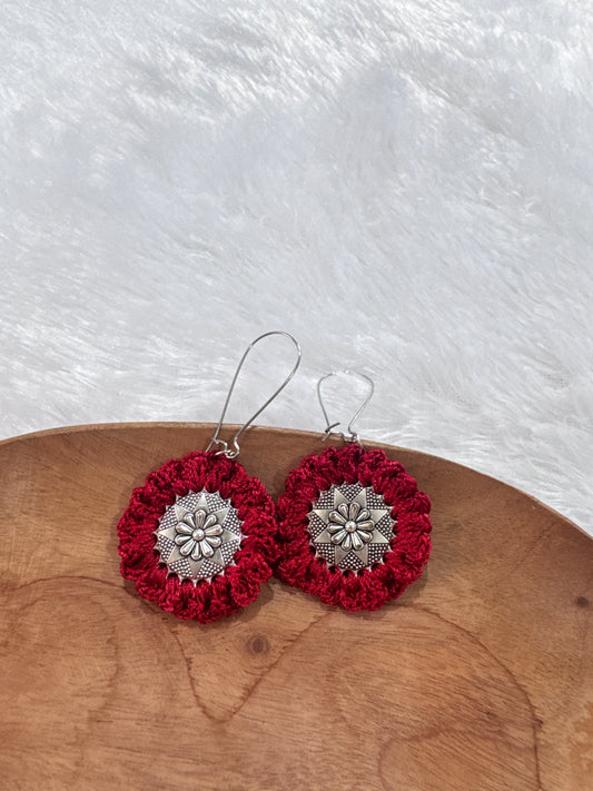 Handmade Ruhi crochet earrings in ruby red featuring a floral metal centerpiece with intricate crochet detailing.