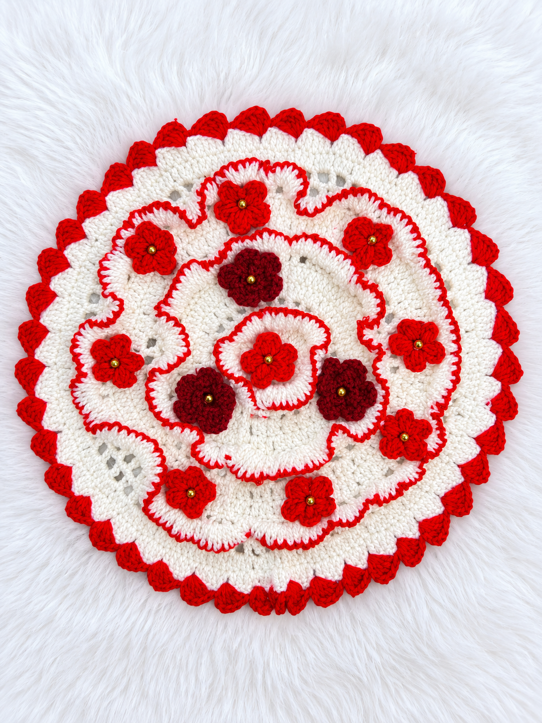 Gulnaar crochet thaal paros in ivory and red with layered floral crochet motifs, maroon flower accents, gold-tone centres and a scalloped border for Diwali pooja décor.