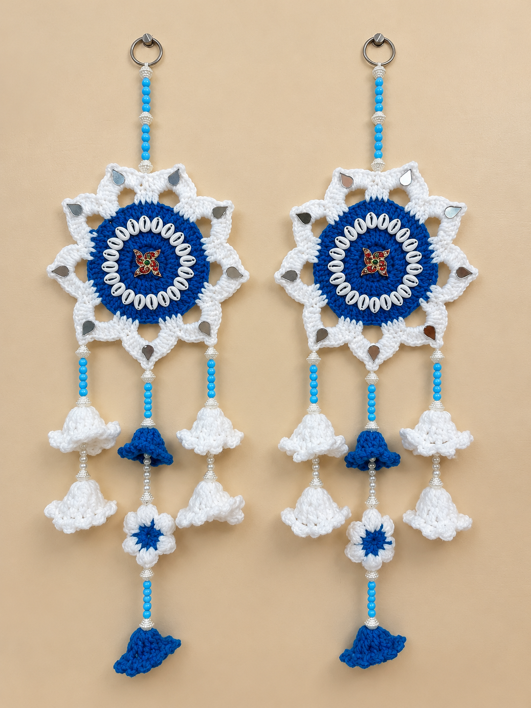 Shwet Neel crochet wall hanging set of 2 in white and royal blue with central Sathiya embellishments, mirror-like accents, beads and crochet bell tassels.