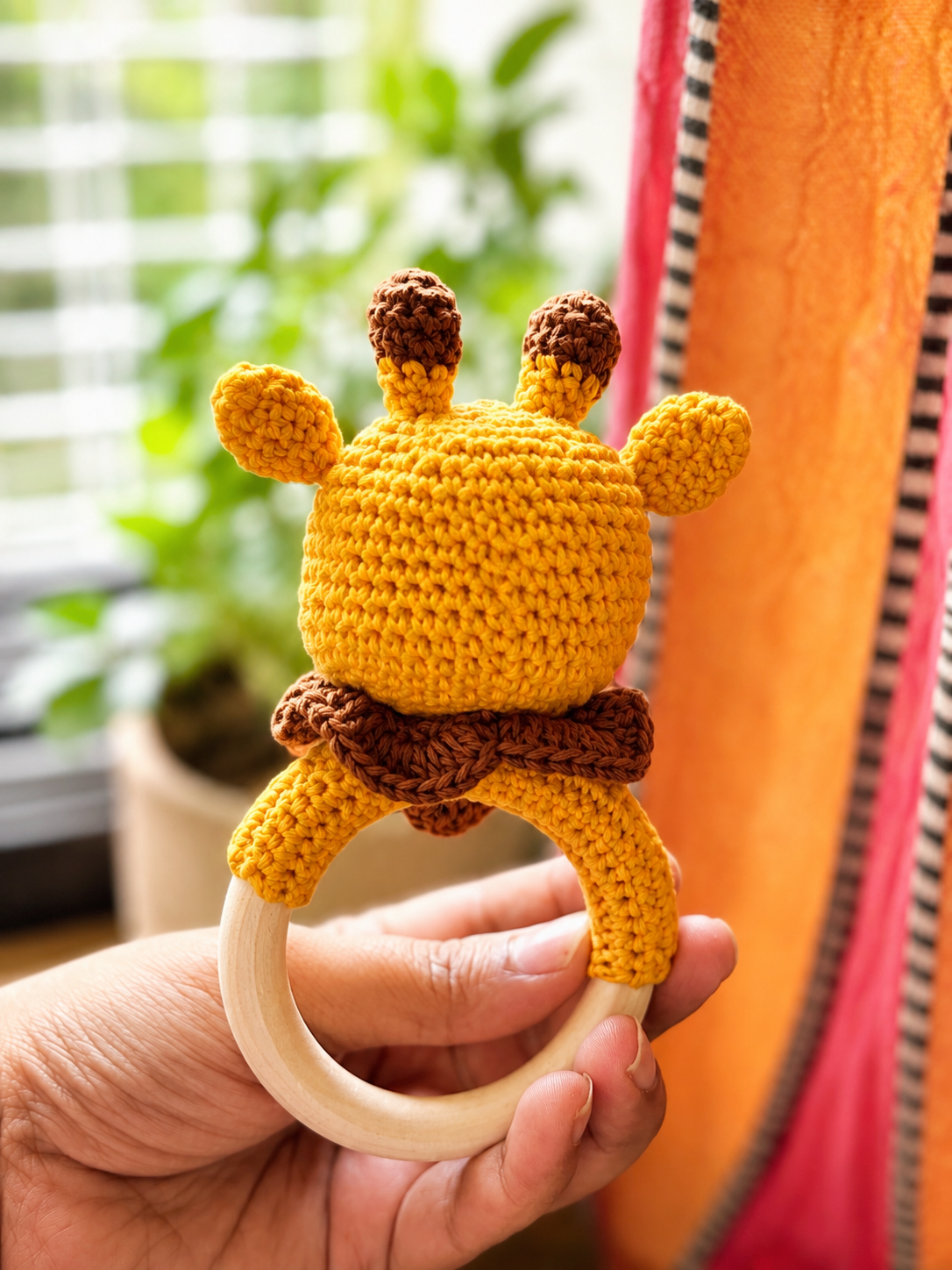 Handcrafted crochet giraffe baby rattle with wooden ring by The Hook Project
