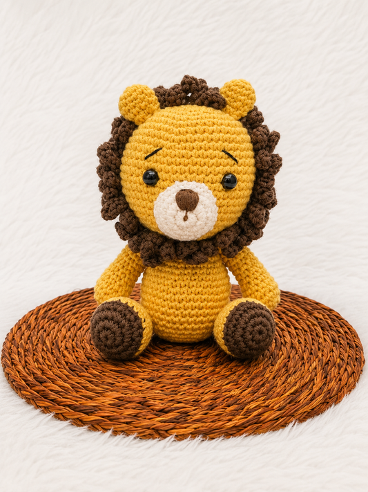 Leo the Crochet Lion handmade amigurumi plush toy with a golden yellow body, textured brown mane, and adorable handcrafted detailing, displayed on a woven mat.