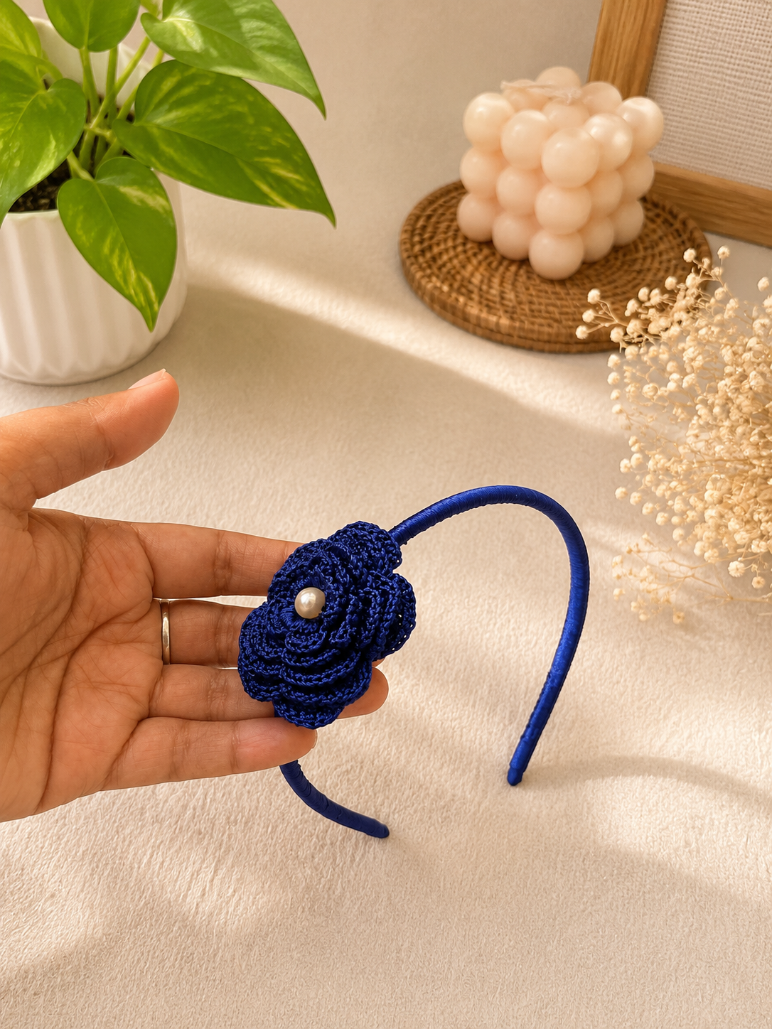 Midnight Bloom crochet flower headband with pearl center and satin-wrapped band by The Hook Project.