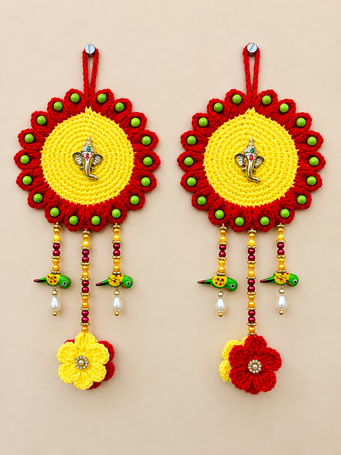 Red and yellow crochet Ganesha wall hanging set of 2 with green beads and floral decorations for Diwali home decor by The Hook Project.