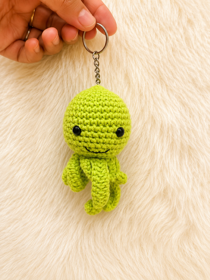 Handmade crochet octopus keychain available in multiple colors and sizes, featuring a smiling amigurumi octopus with curled tentacles and metal keyring by The Hook Project.