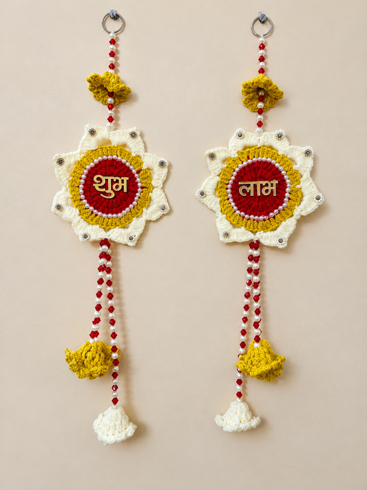 Shubh Labh Marigold crochet wall hanging set of 2 in red, mustard yellow and ivory with gold Hindi lettering, pearl-like details and beaded crochet tassels.