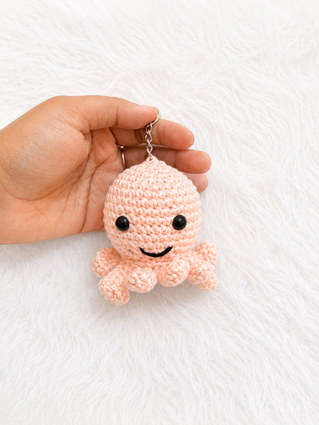 Handmade crochet octopus keychain available in multiple colors and sizes, featuring a smiling amigurumi octopus with curled tentacles and metal keyring by The Hook Project.