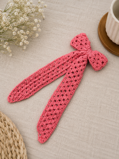 Handmade pink crochet bow hair clip attached to secure metal tic tac clips, crafted with premium cotton yarn by The Hook Project.