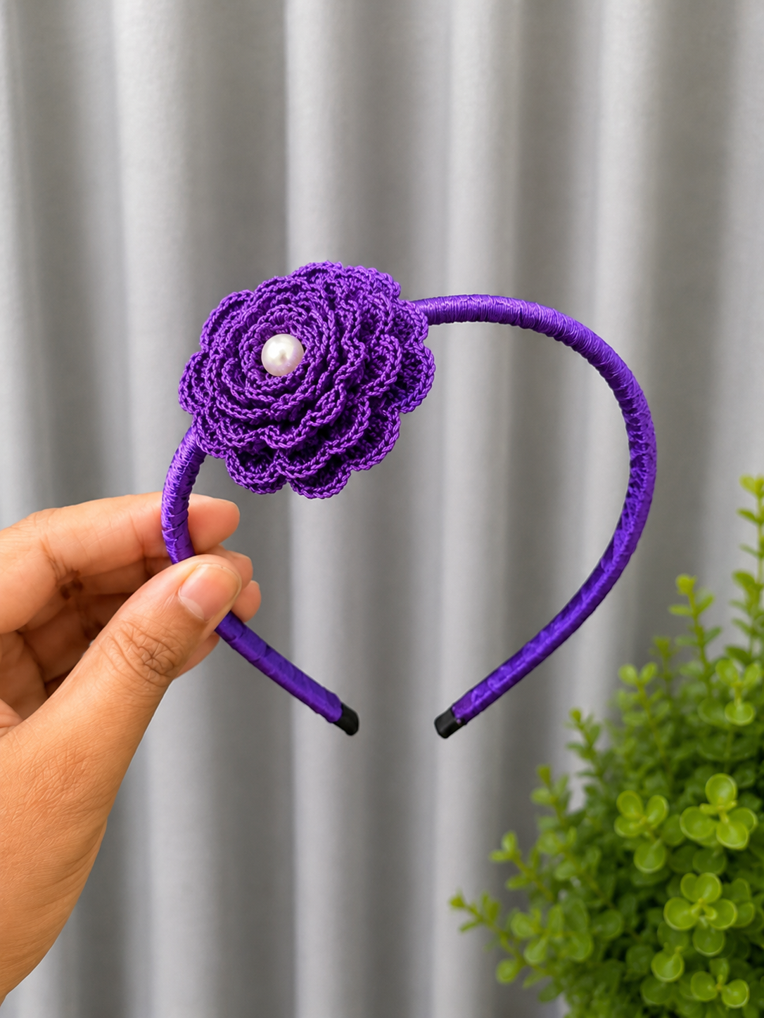 Handmade royal violet crochet floral headband featuring a layered flower with pearl center on a satin-wrapped headband.