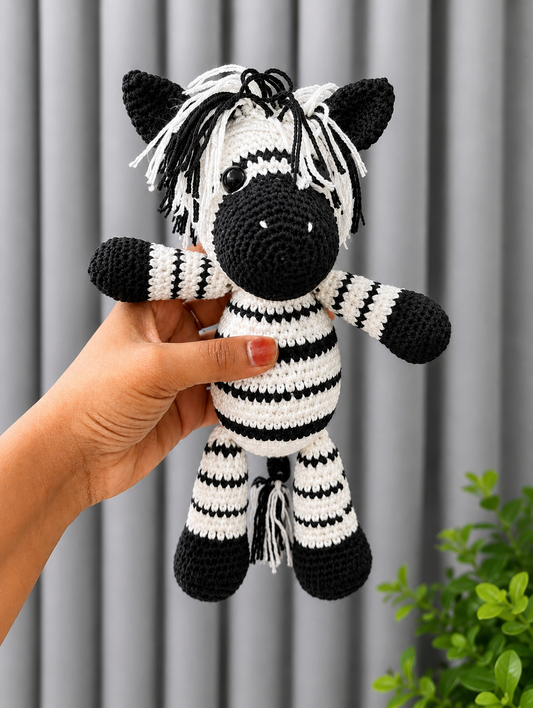 Handmade black and white crochet zebra amigurumi plush toy with yarn mane and striped body, crafted from premium cotton yarn.