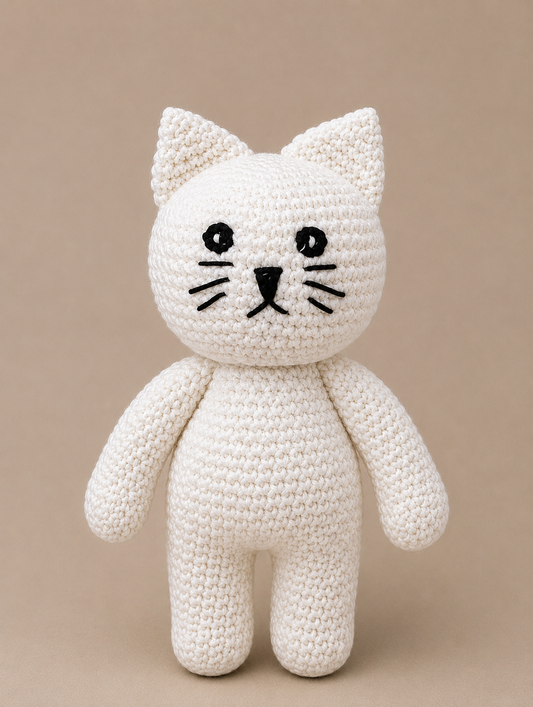Handmade crocheted white cat toy on a beige background