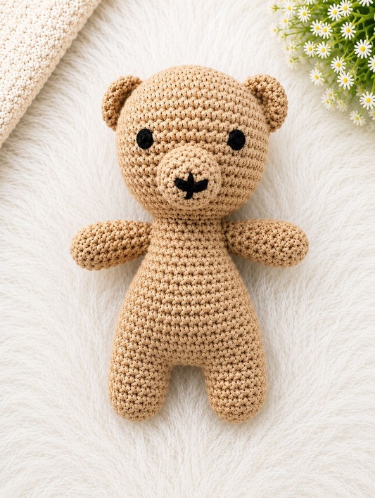 Handmade beige crochet teddy bear soft toy crafted from cotton yarn, displayed on a soft white fur background.