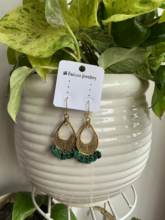 Handmade emerald green crochet drop earrings featuring antique gold teardrop charms and intricate crochet detailing by The Hook Project.